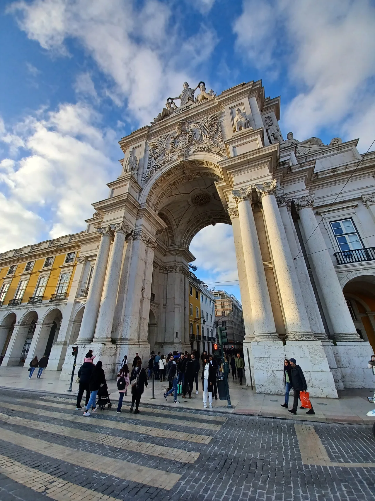 Fachada esculpida e colunas do Arco da Rua Augusta vistas de baixo.
