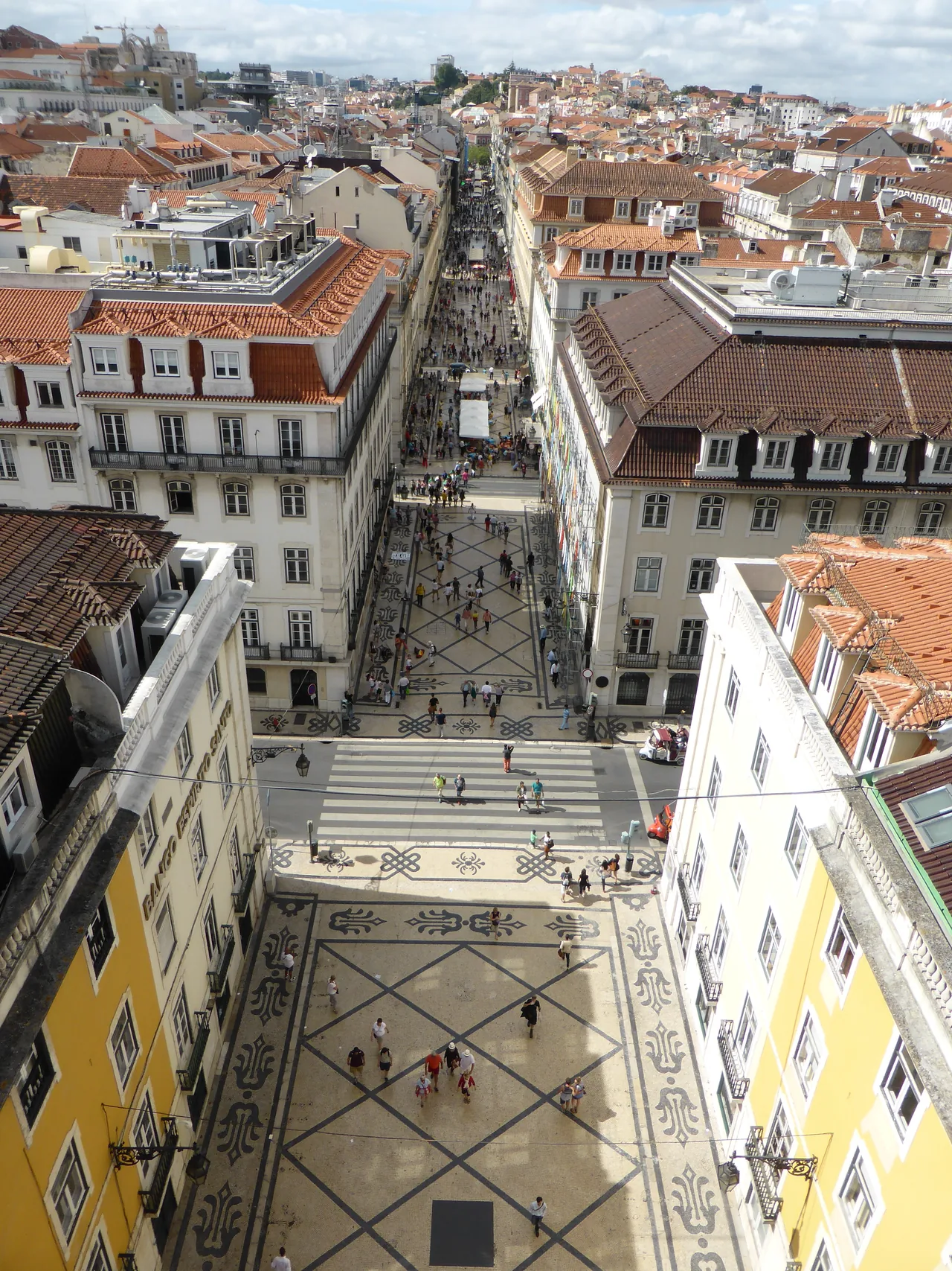 Rua Augusta a estender-se entre filas de edifícios, vista do topo do arco.