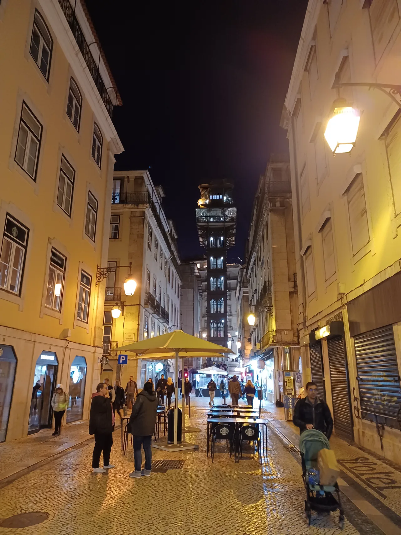 The illuminated Santa Justa Lift at the end of a narrow street in Baixa.