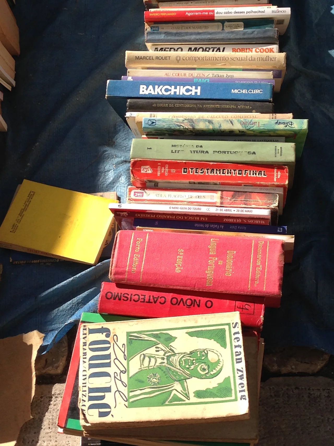 Uma pilha de livros em segunda mão à venda na Feira da Ladra.