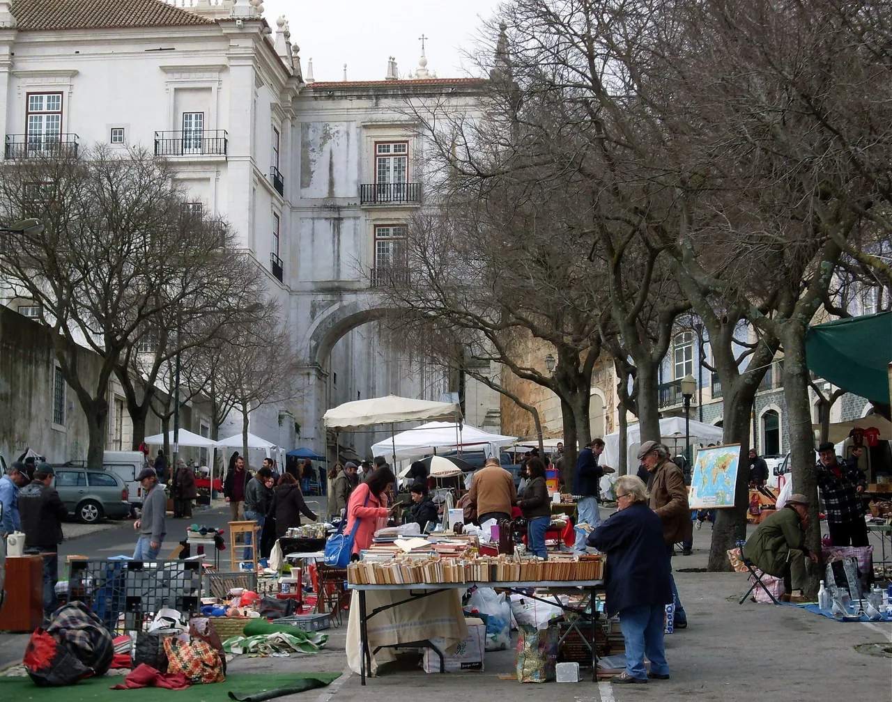 Mesas com objetos em segunda mão sob as árvores na Feira da Ladra.