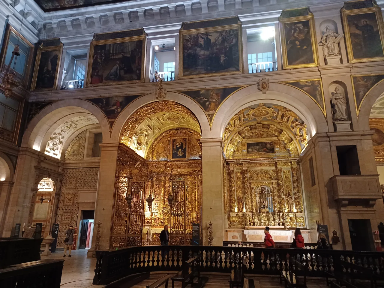 Capelas douradas enquadradas por arcos de pedra clara no interior de São Roque.