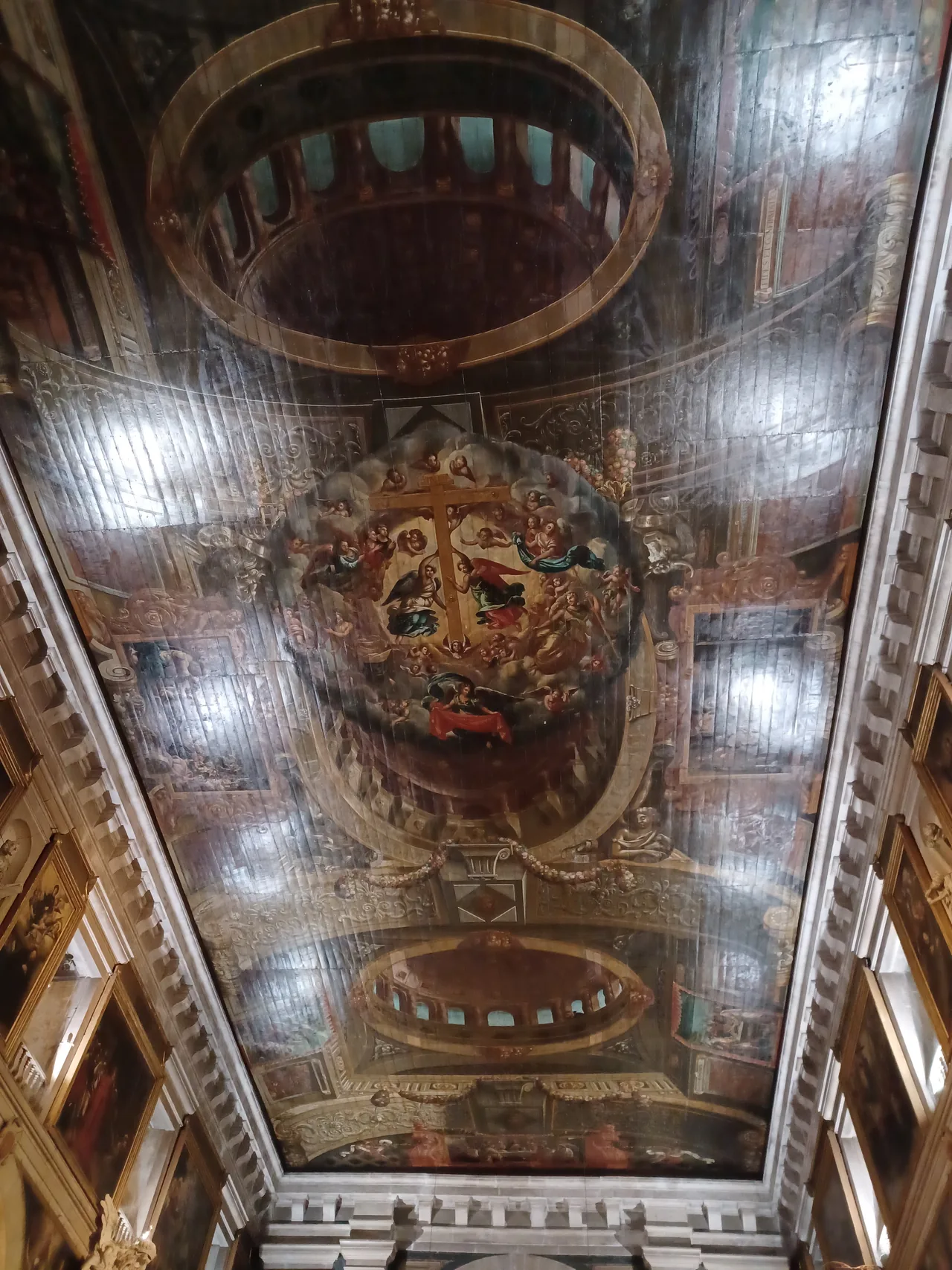 Pormenores arquitetónicos pintados e cenas religiosas no teto de madeira de São Roque.