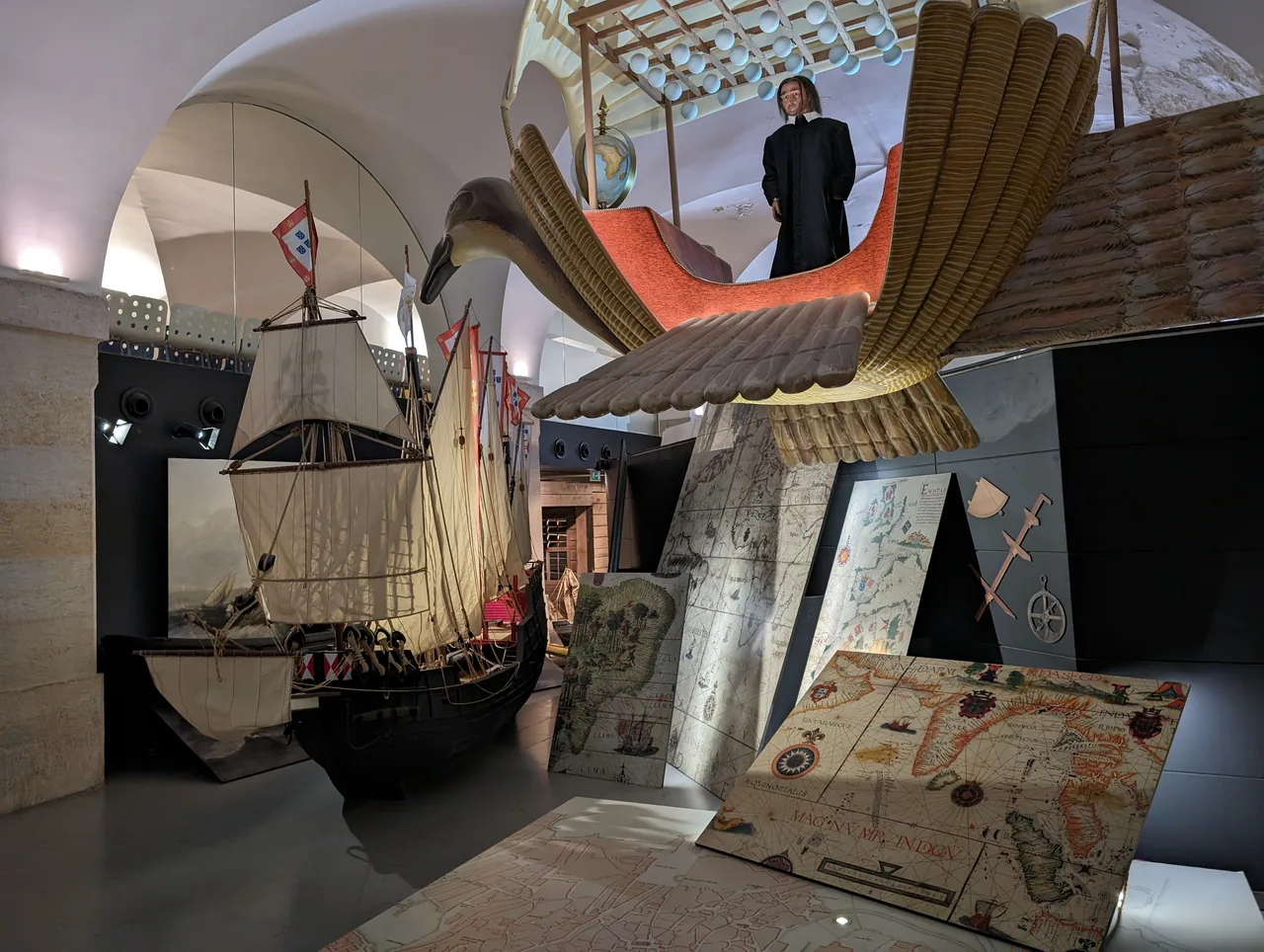 Ship and flying-machine models beneath vaulted ceilings at Lisboa Story Centre