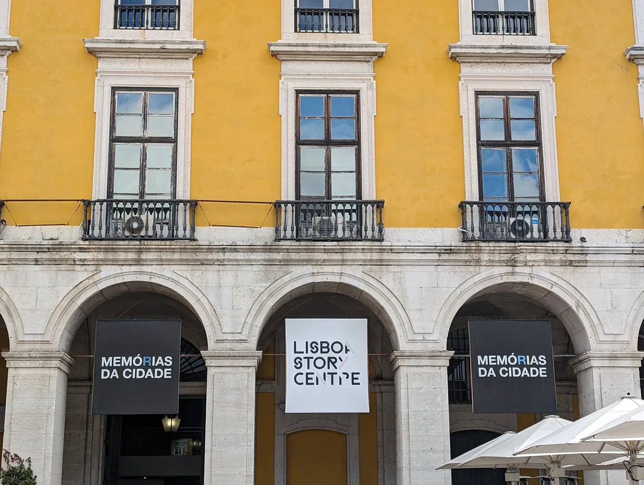 Lisboa Story Centre entrance beneath the yellow façade of Praça do Comércio