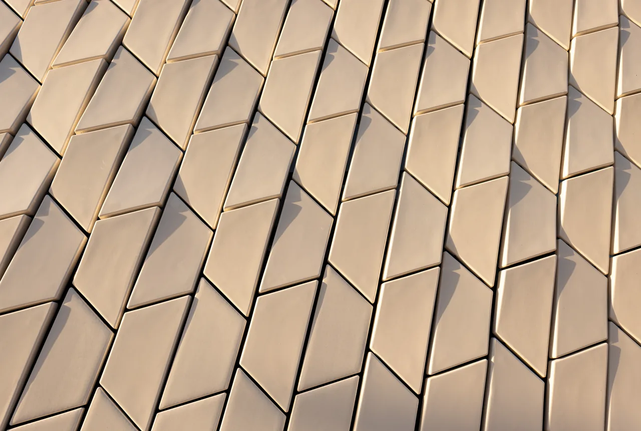 A close view of the overlapping three-dimensional ceramic tiles on MAAT’s façade.
