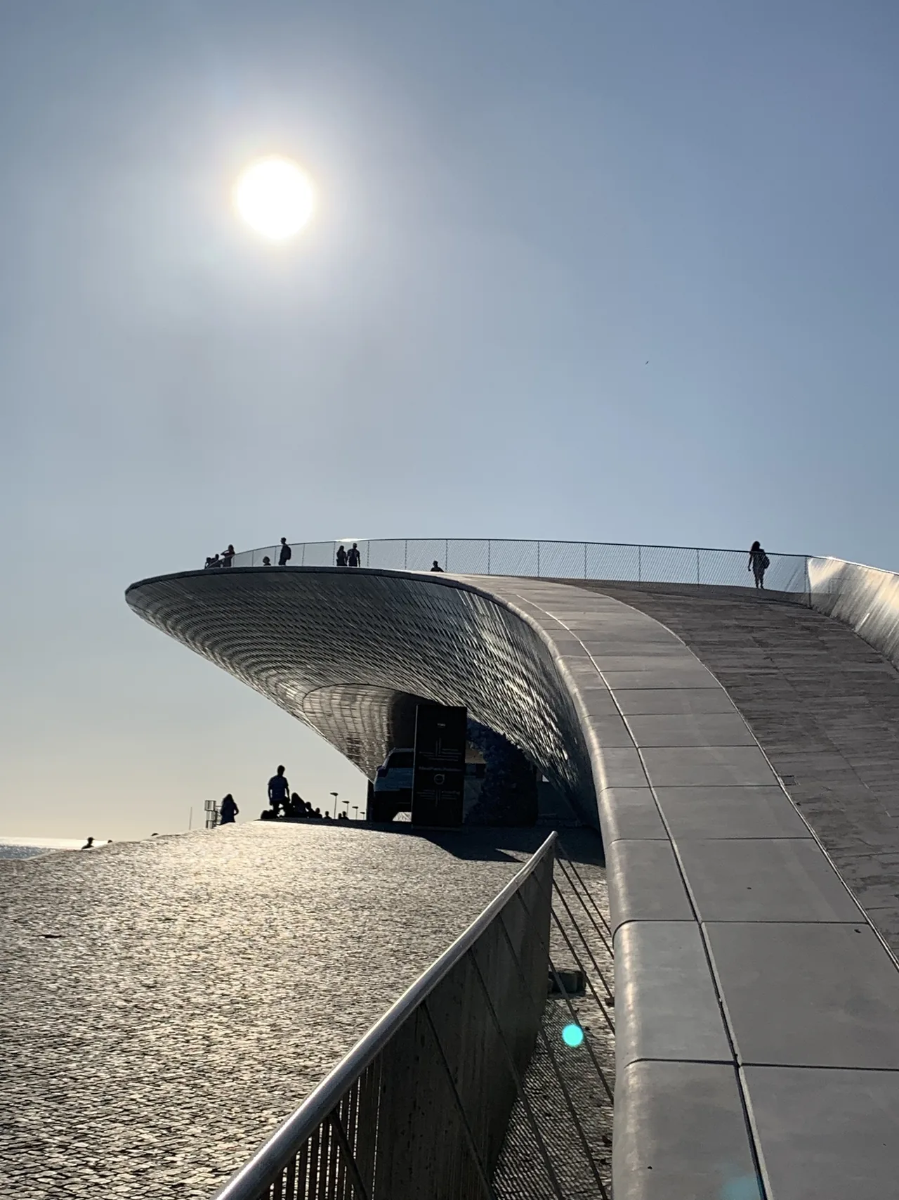 Visitors on MAAT’s curved roof above the shaded entrance.