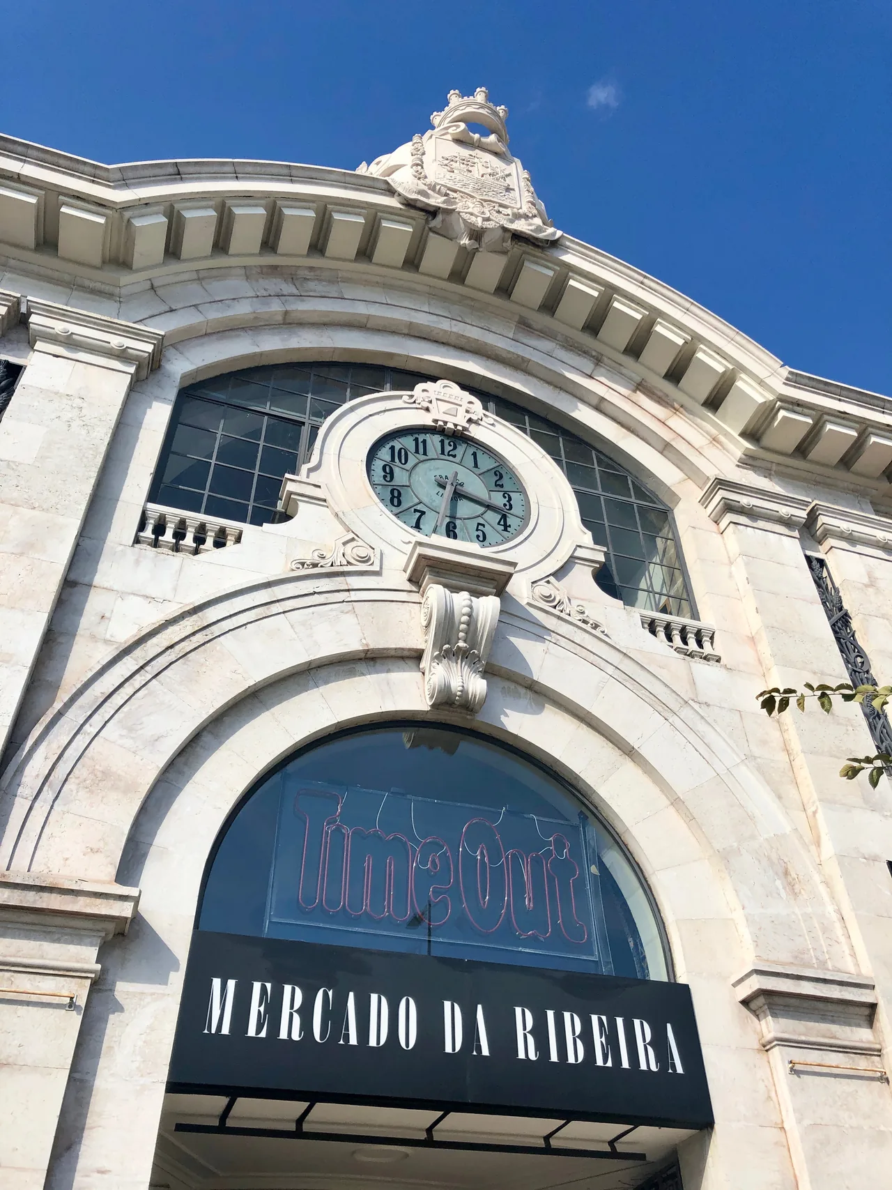 Relógio, frontão esculpido e entrada em arco do Mercado da Ribeira.