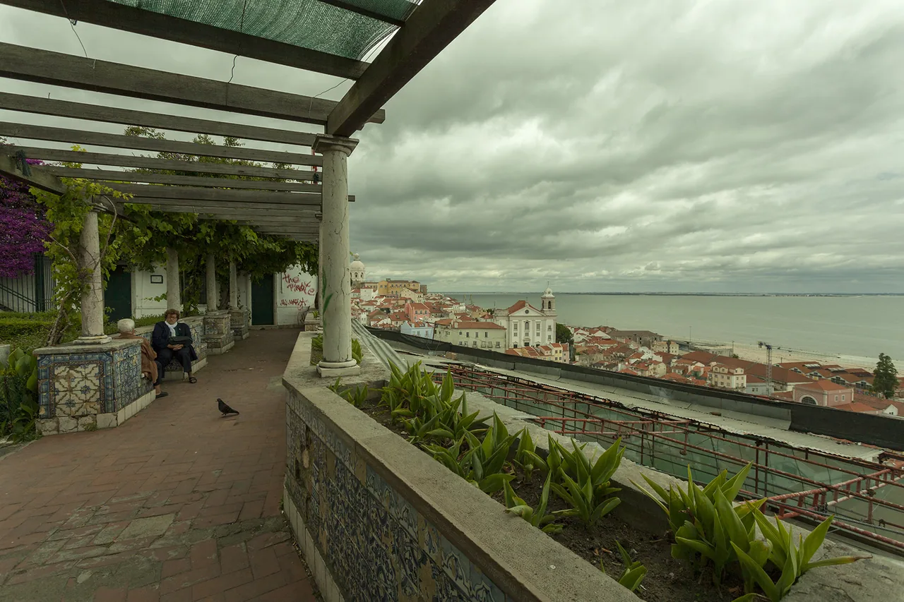 The tiled walls and pergola at Santa Luzia framing a view of Alfama and the Tagus.