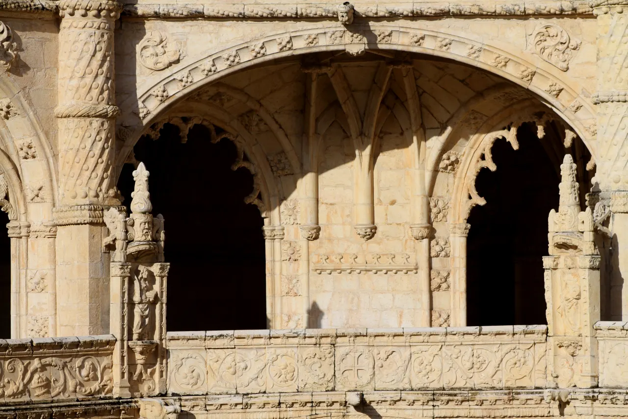 Carved columns, figures and decorated arches in the cloister of Jerónimos Monastery.