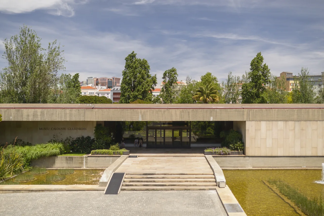 Broad steps and a reflecting pool in front of the low concrete façade of the Calouste Gulbenkian Museum.
