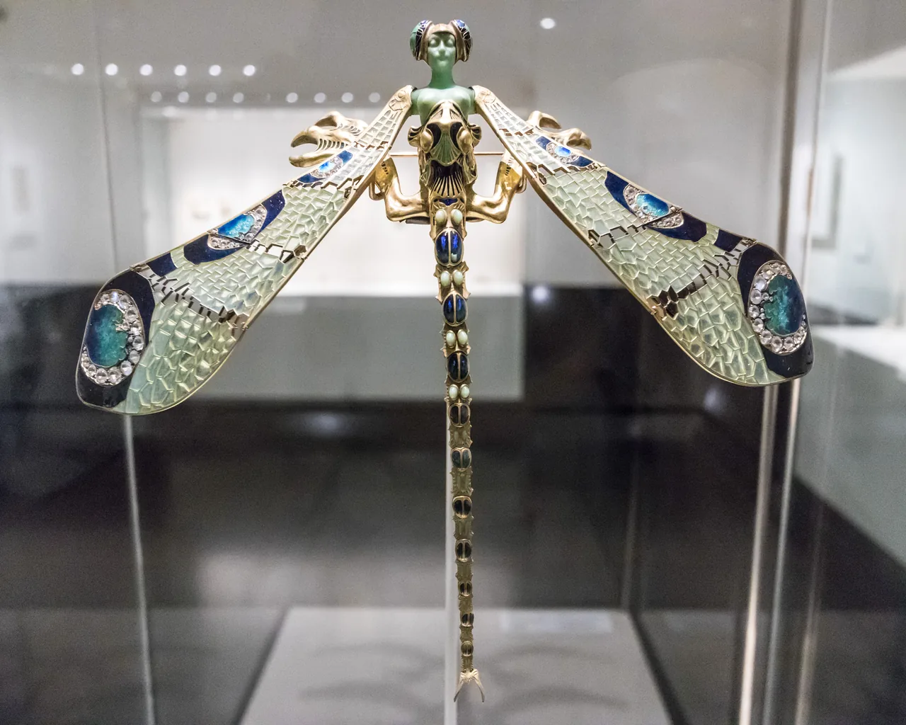 René Lalique's dragonfly corsage ornament, with a green female head and spread enamelled wings.