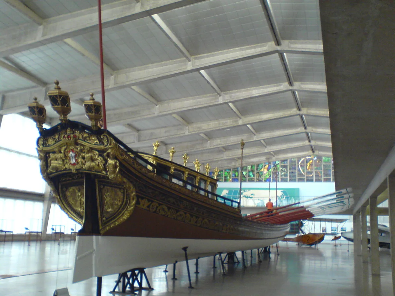 El largo casco y la decoración dorada de la falúa real de María I en el Museo de Marina.