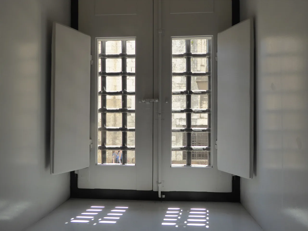 Luz del sol que entra por una ventana con barrotes en una sala del Museo del Aljube