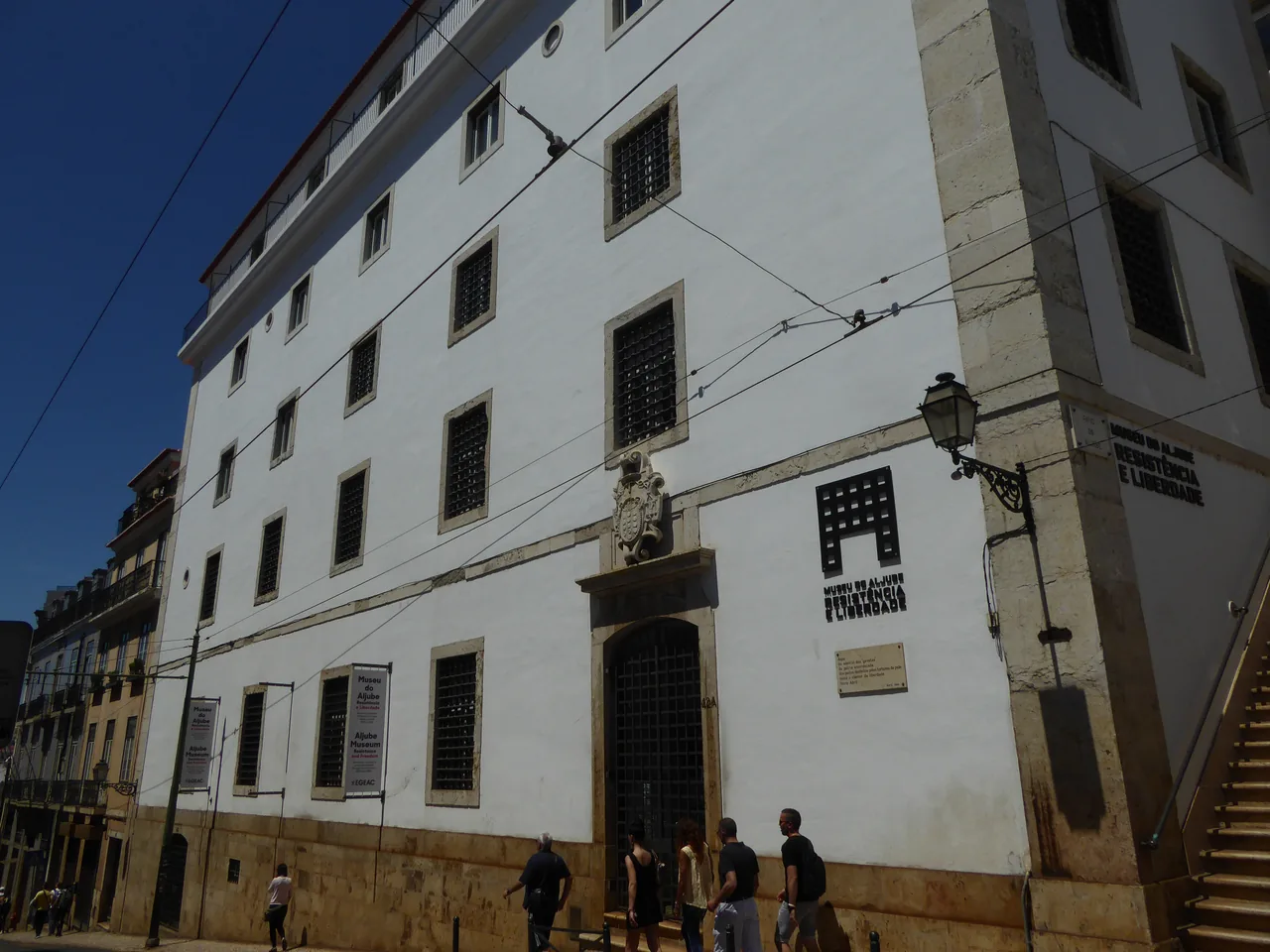 White façade and stone doorway of the Aljube Museum beside the cathedral
