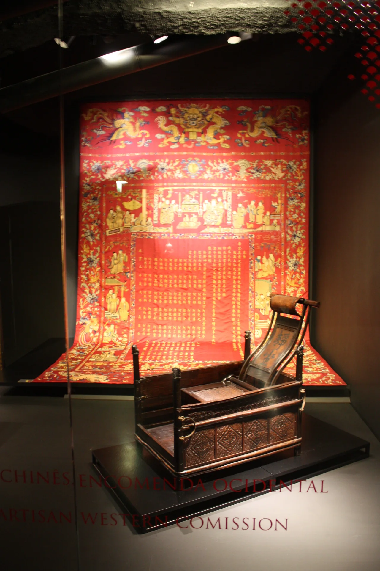 Reclining chair in front of a richly decorated red textile at the Museum of the Orient