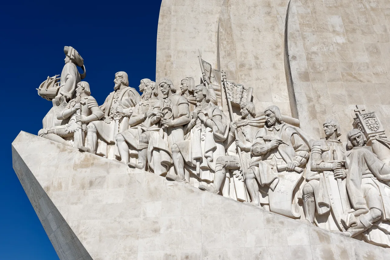A row of stone figures along the side of the Monument to the Discoveries.