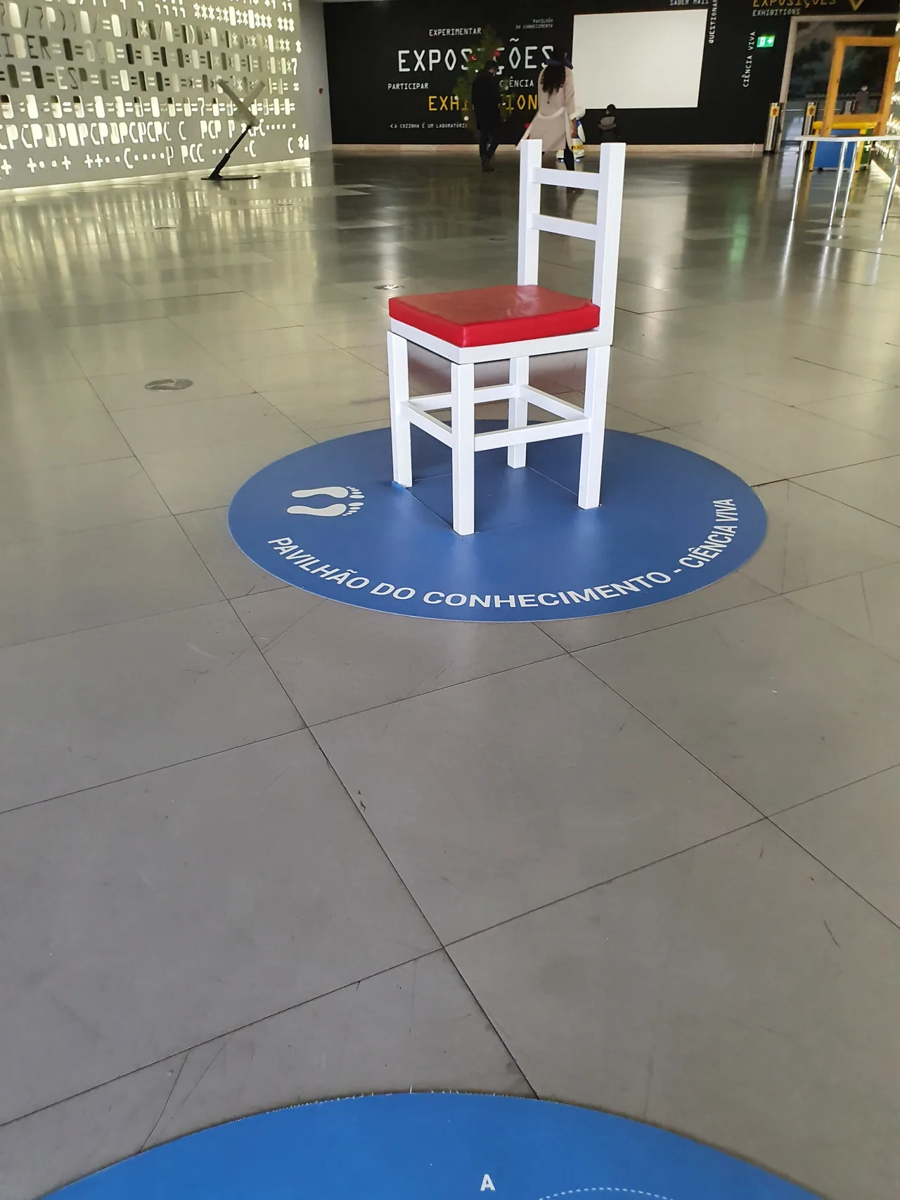 A white and red chair used in a perspective experiment at Pavilhão do Conhecimento