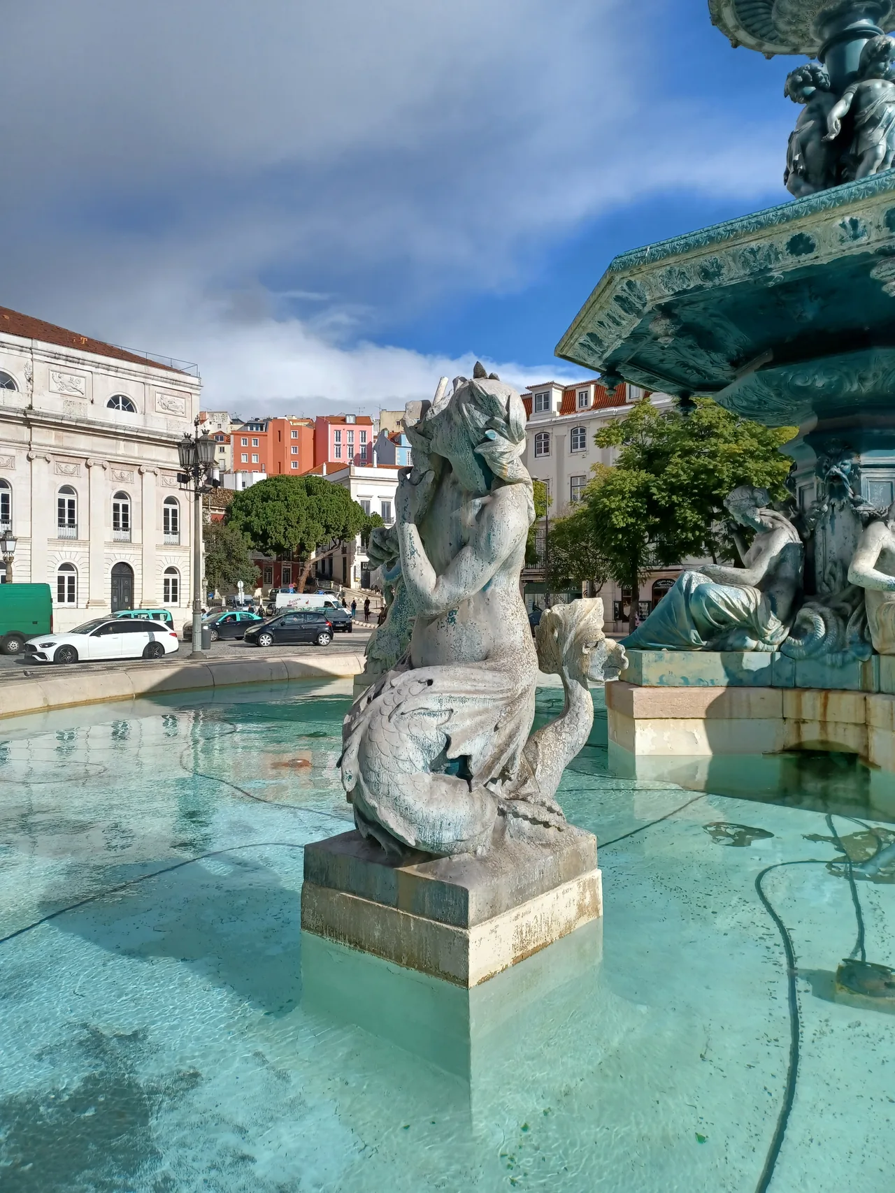 Agua que cae alrededor de las figuras de bronce de una fuente de Rossio.