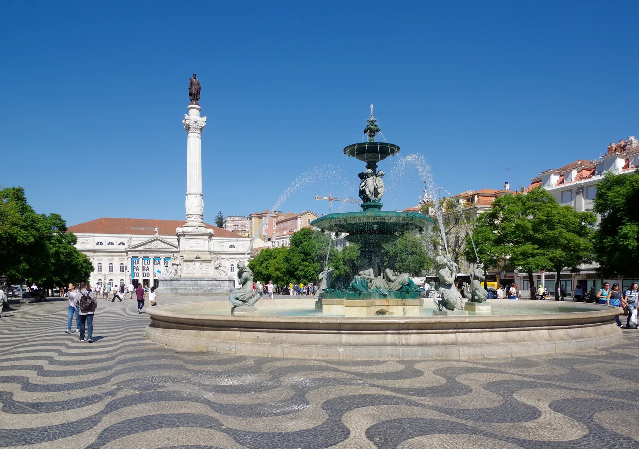 A bronze fountain and the column of Pedro IV in Rossio square.