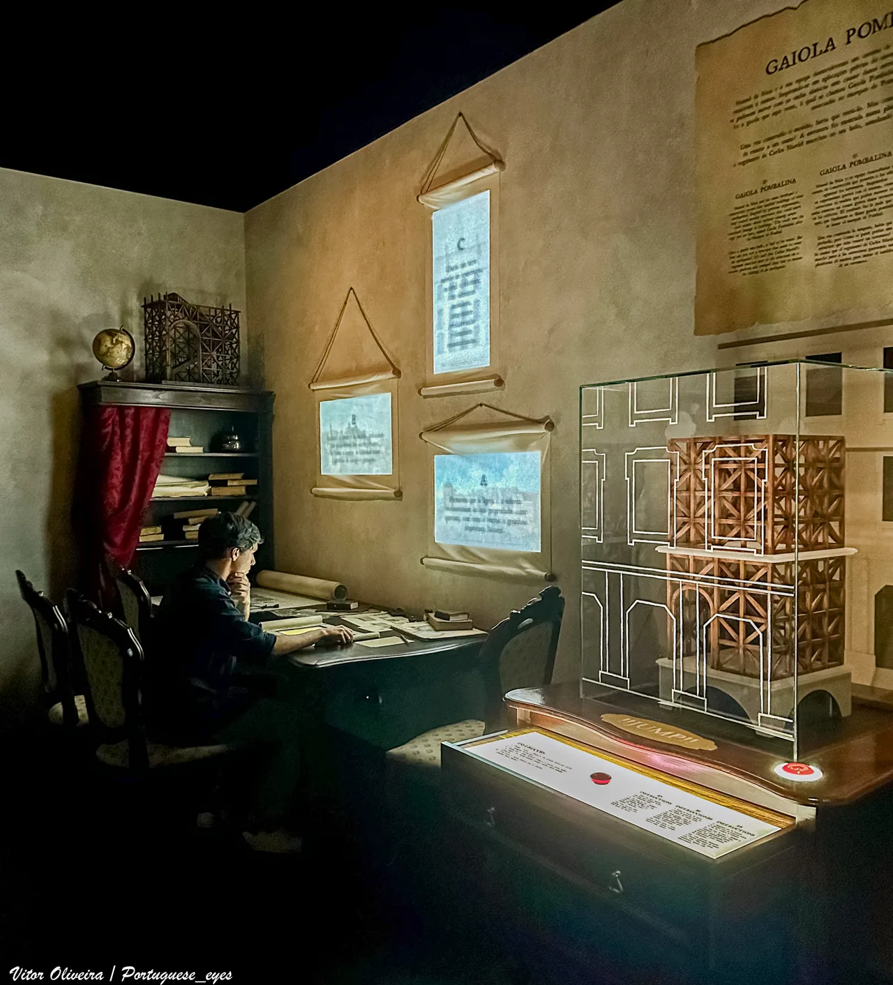 Un visitante junto a una maqueta de un entramado de madera y dibujos proyectados en Quake.