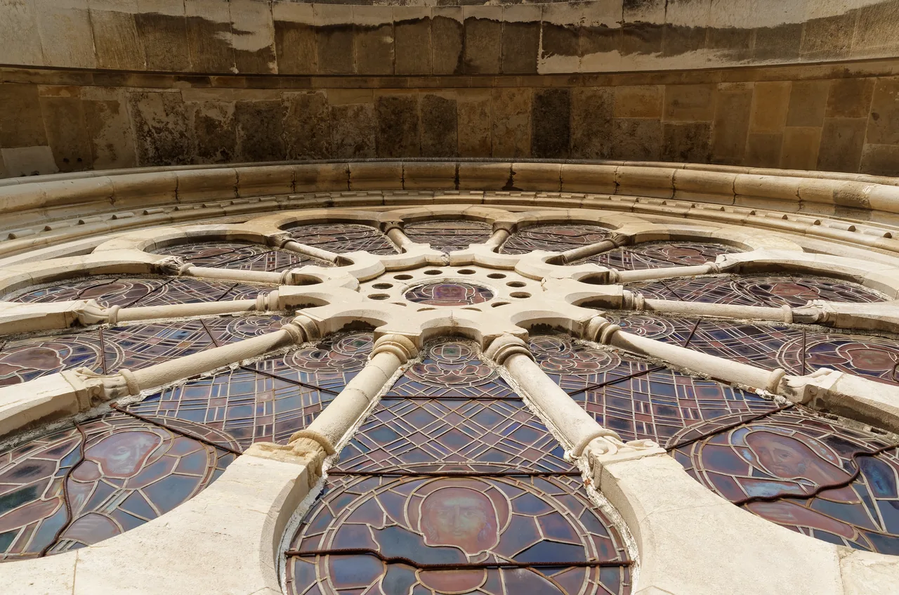 The tracery and stained glass of Lisbon Cathedral’s rose window, seen close up from below.