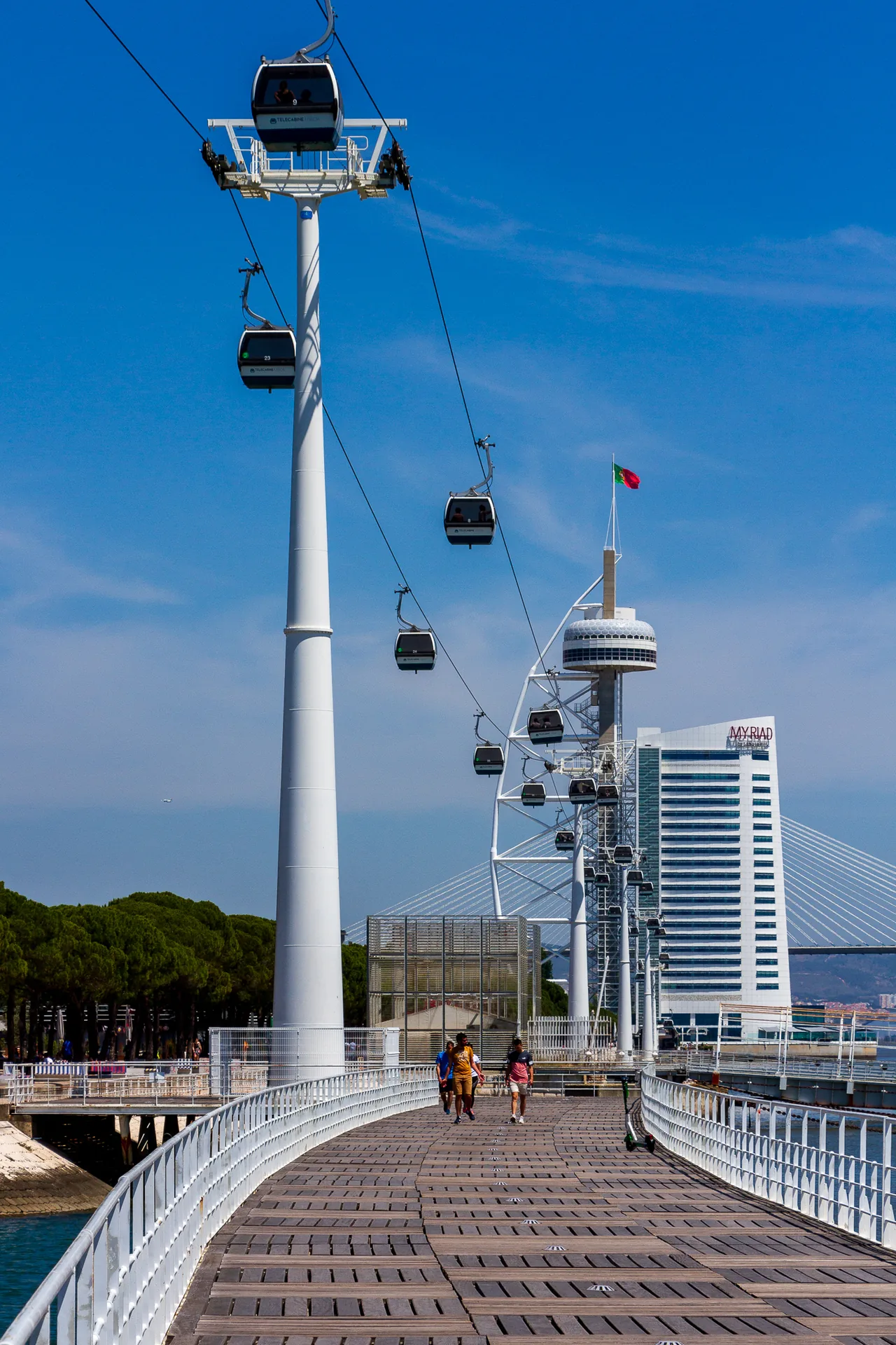 Cabina da Telecabine a passar junto a um pilar de suporte sobre o passeio ribeirinho.