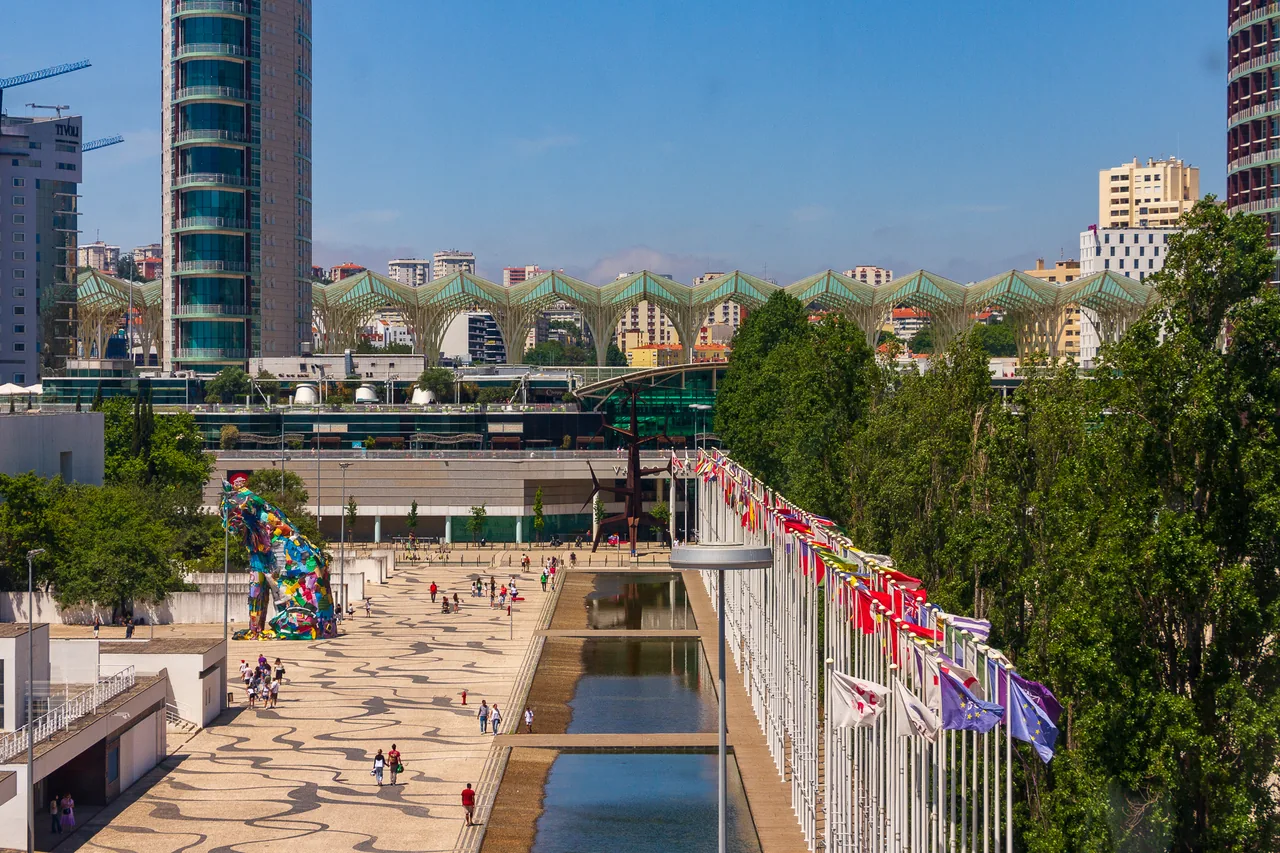 Jardins, caminhos e visitantes no Parque das Nações vistos de uma cabina da telecabine.
